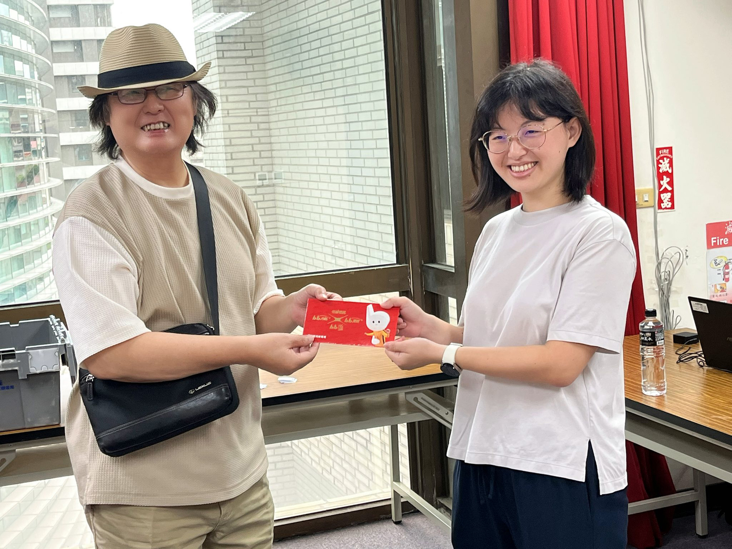 楊心怡理事長（圖左）提供「中華漫畫家協會獎」獎金給中崙分館許淑莉主任。（圖片提供∕北市圖中崙分館）