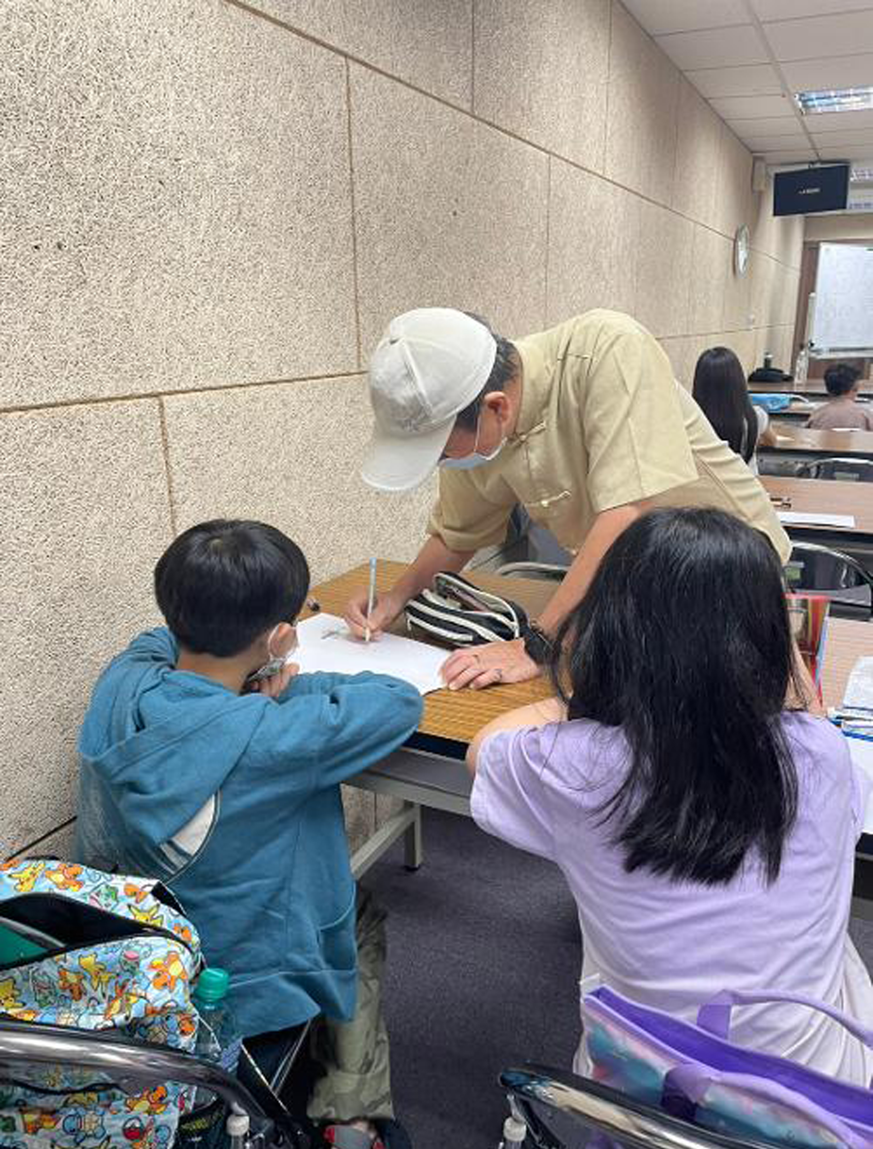 鄭松維老師手把手教導學童如何勾勒漫畫造型。（圖片提供∕中崙分館）